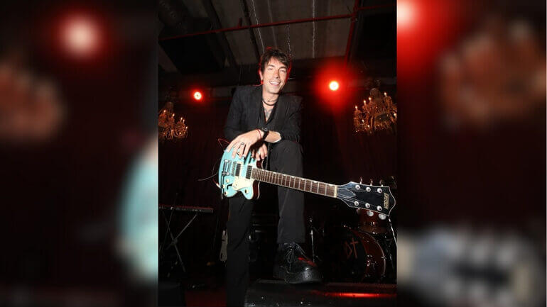 Di Ferrero usando terno com uma guitarra azul clara